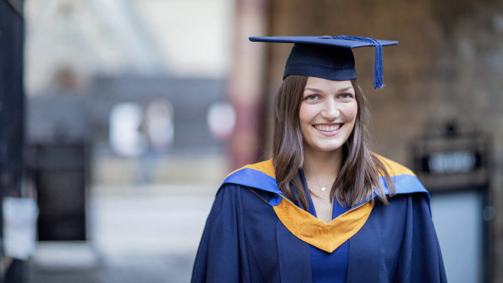 Die Psychologiestudentin Muriel trägt auf ihrer Absolvent:innenfeier einen blauen Talar